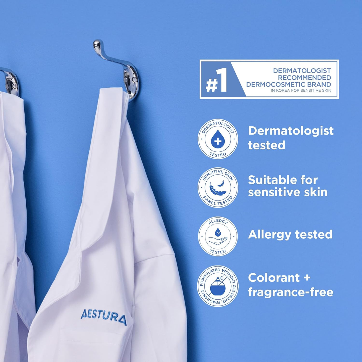 White Aestura dermatologist-tested skincare lab coats hanging on metal hooks against a bright blue wall, with text callouts highlighting product benefits.