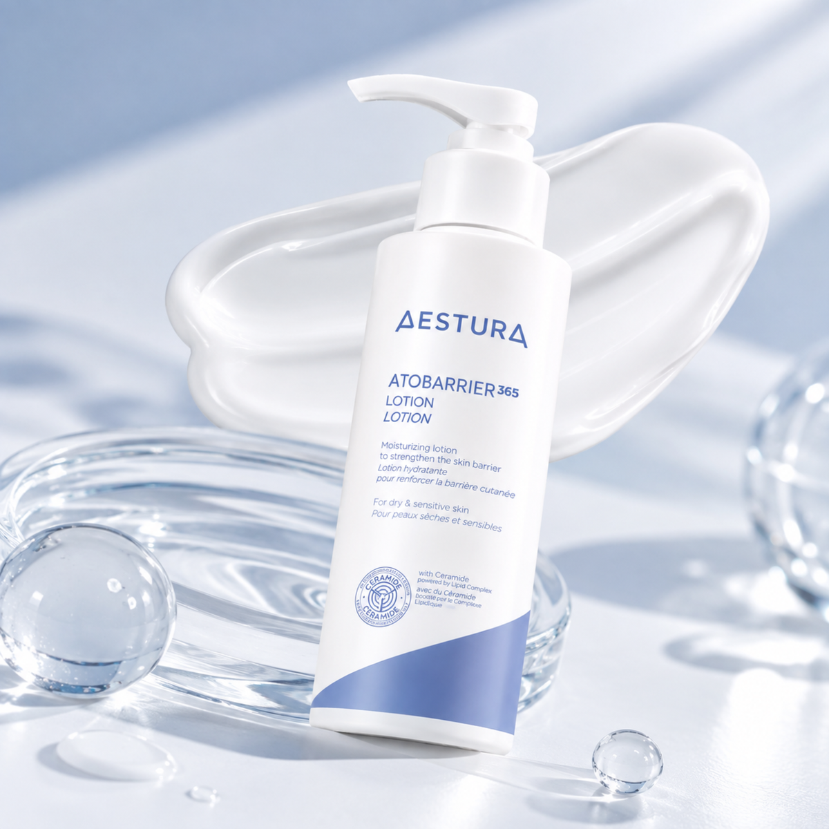 A bottle of AESTURA AtobARRIER 365 Lotion Lotion standing upright on a glossy white surface, with a white cream smear behind it and clear glass droplets around it in a bright, clean studio setting.