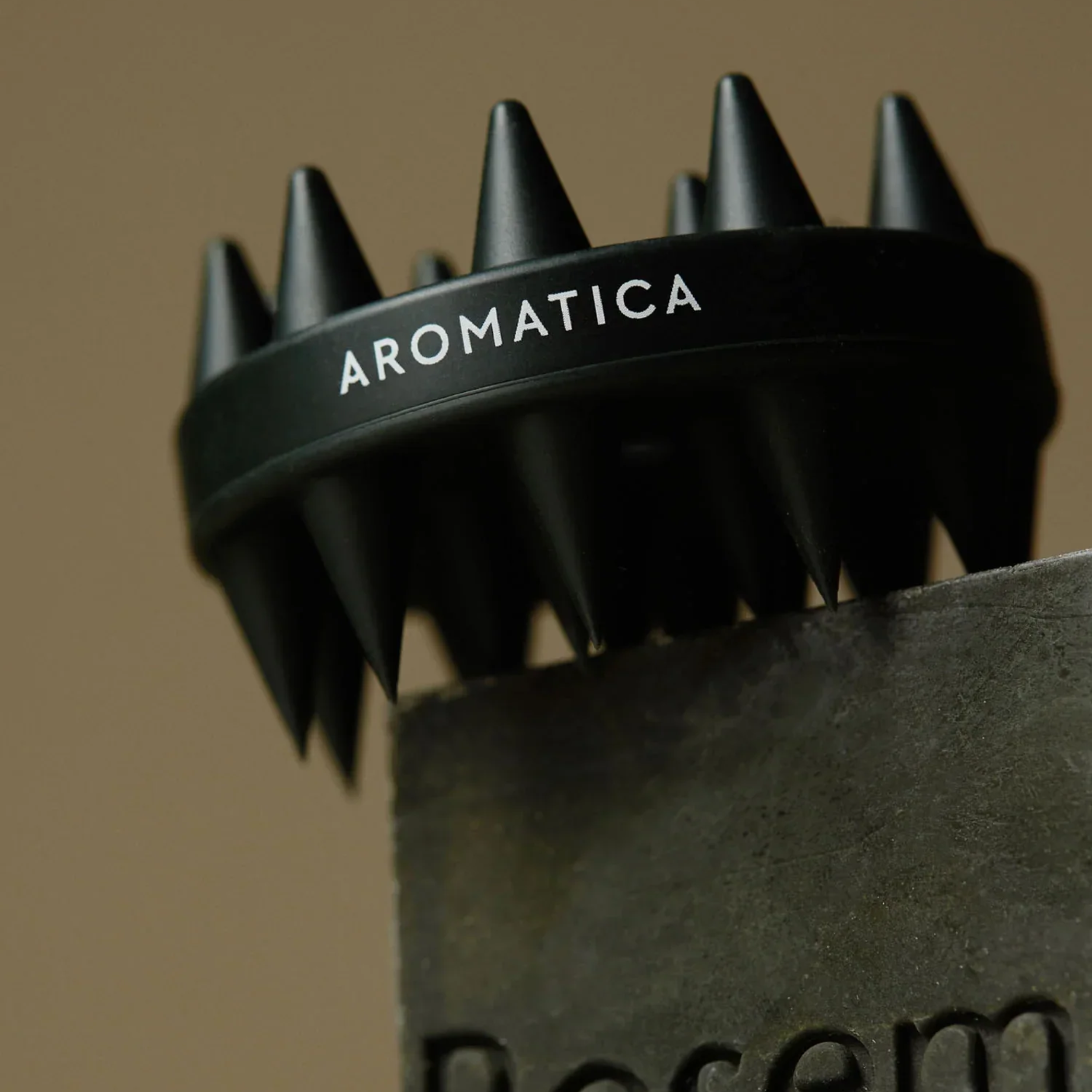Black hair dryer with 'Aromatica' branding on a brown background