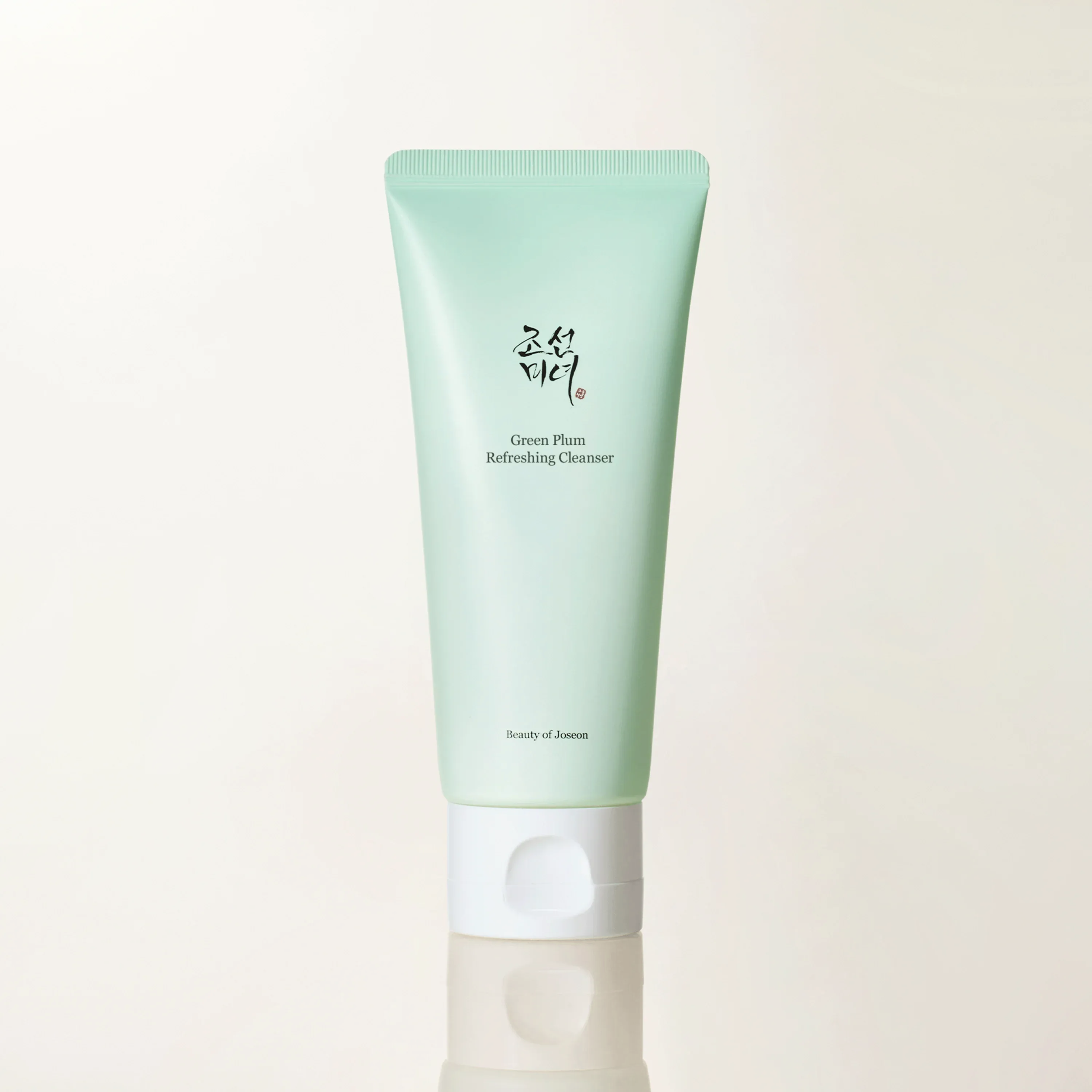 Tube of Green Plum Refreshing Cleanser on a light beige background