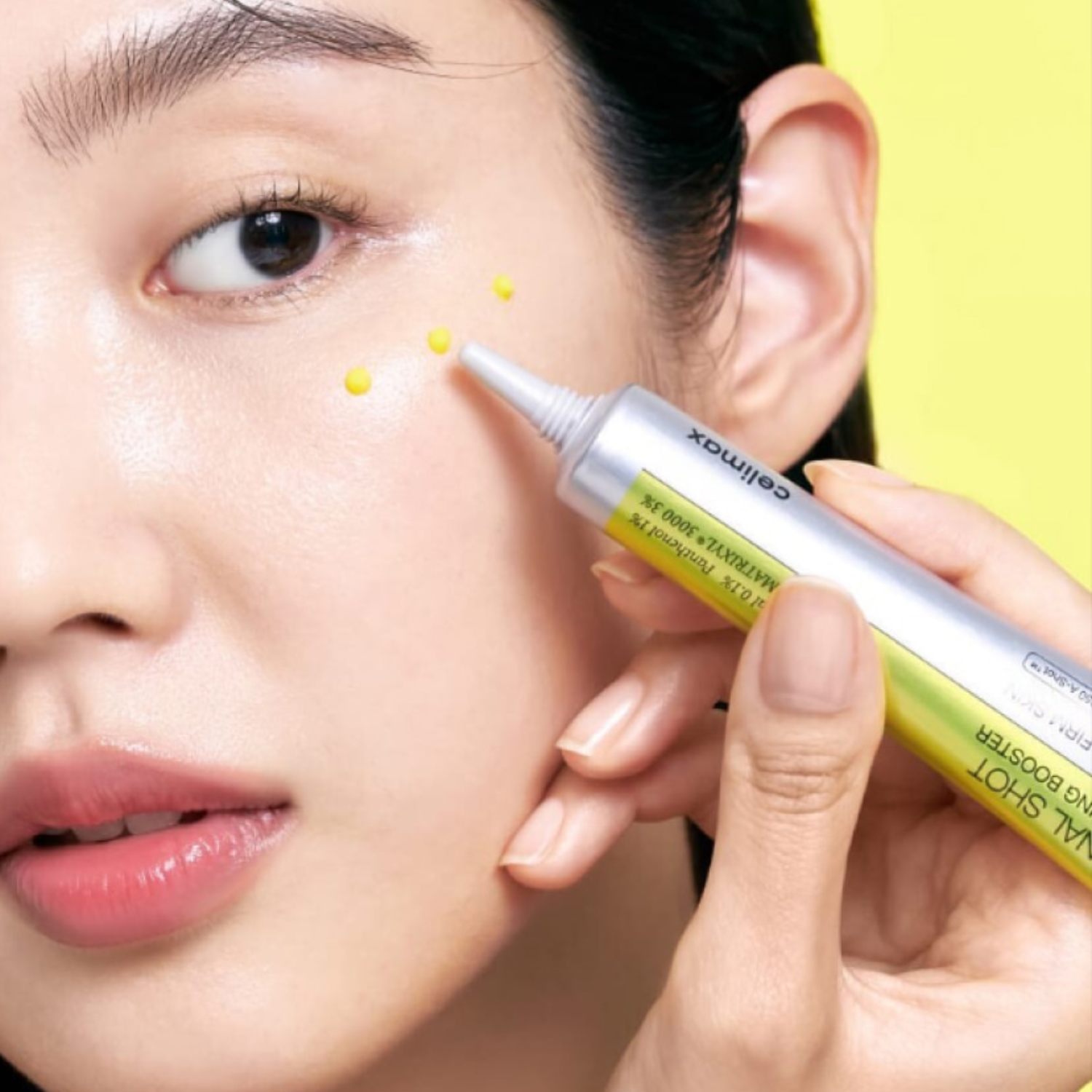 Person applying a cosmetic product to their face with a pen-like applicator.