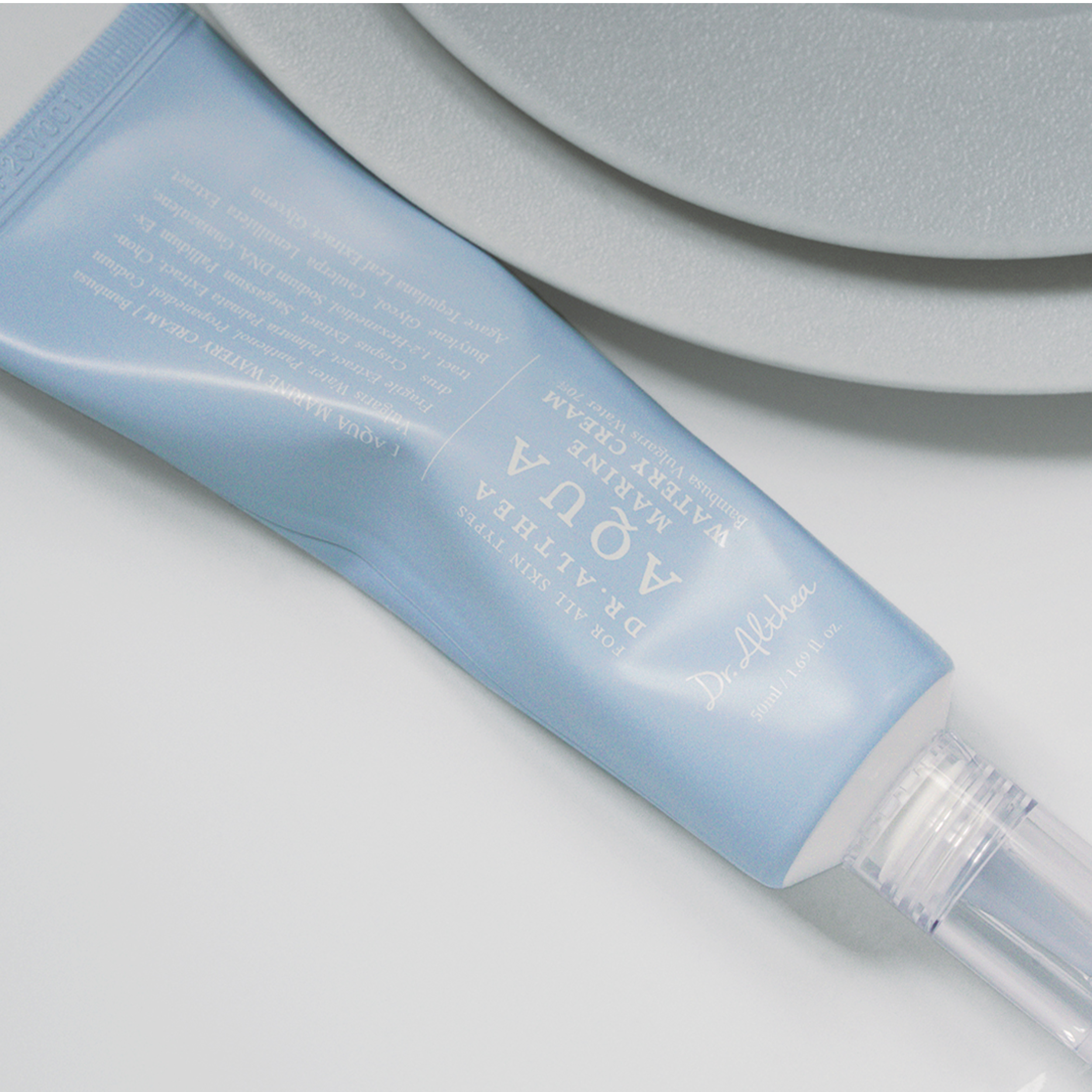 Blue skincare tube with visible brand name on a light gray background
