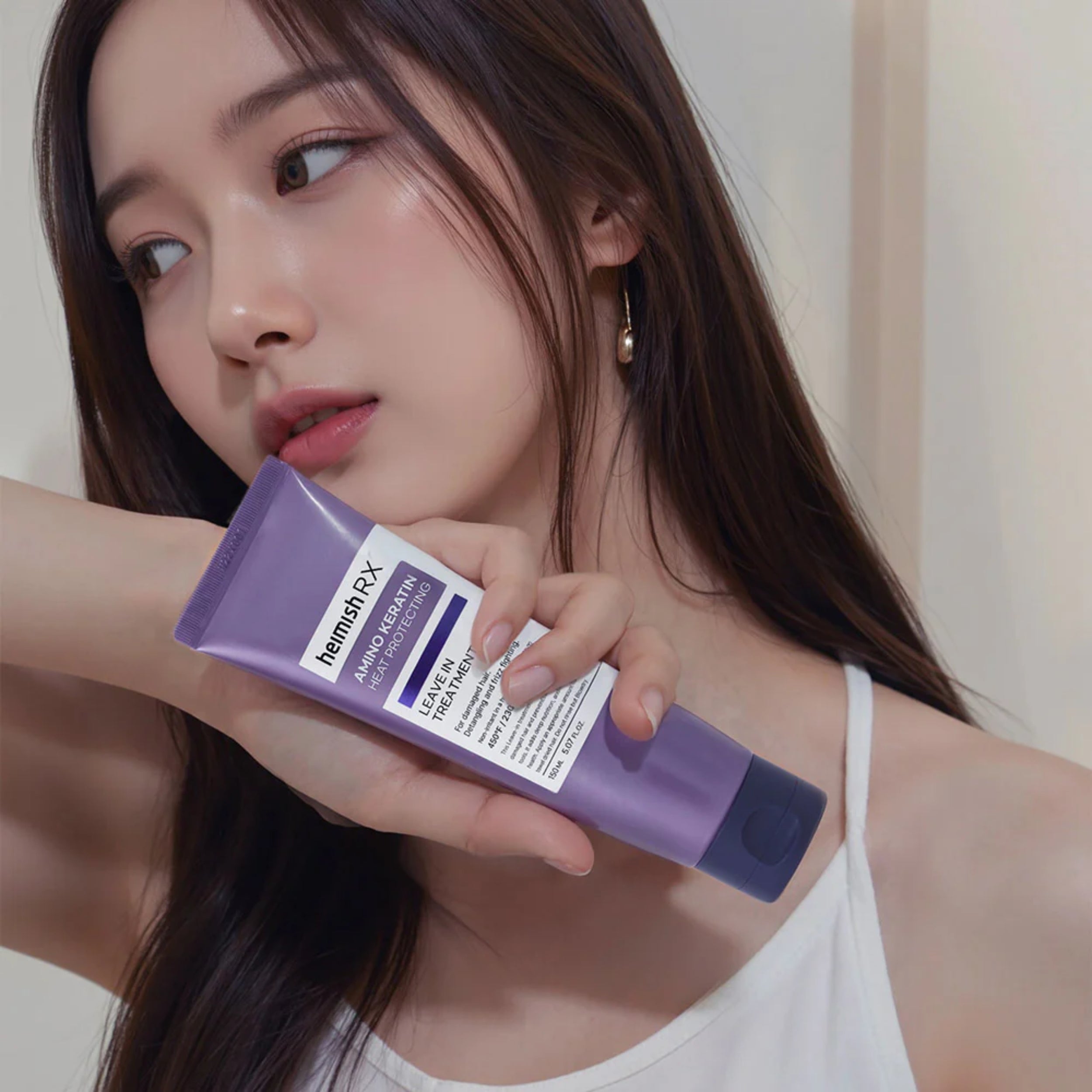 Woman holding a purple bottle labeled 'herman RX' against a neutral background