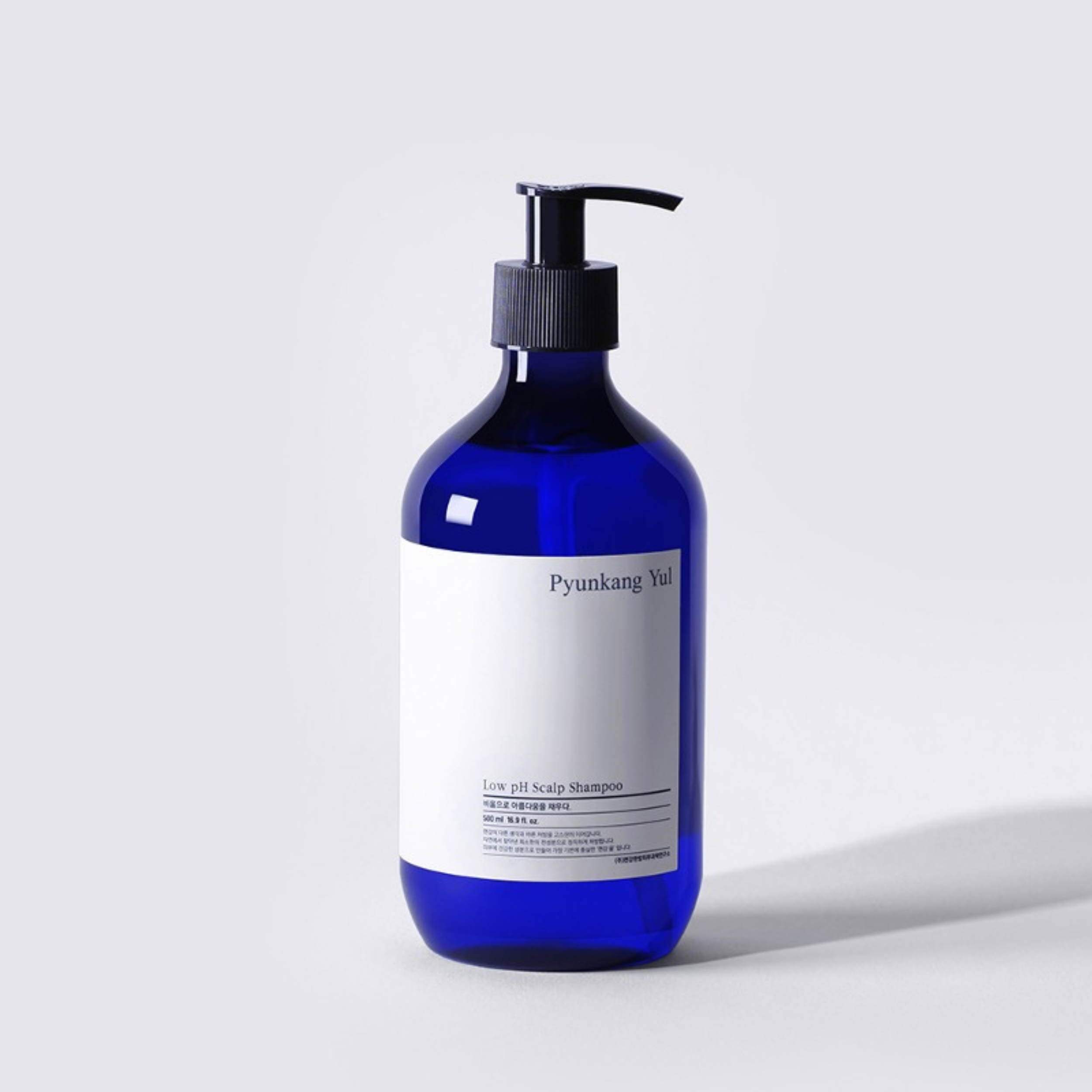 Blue shampoo bottle with a pump on a light gray background