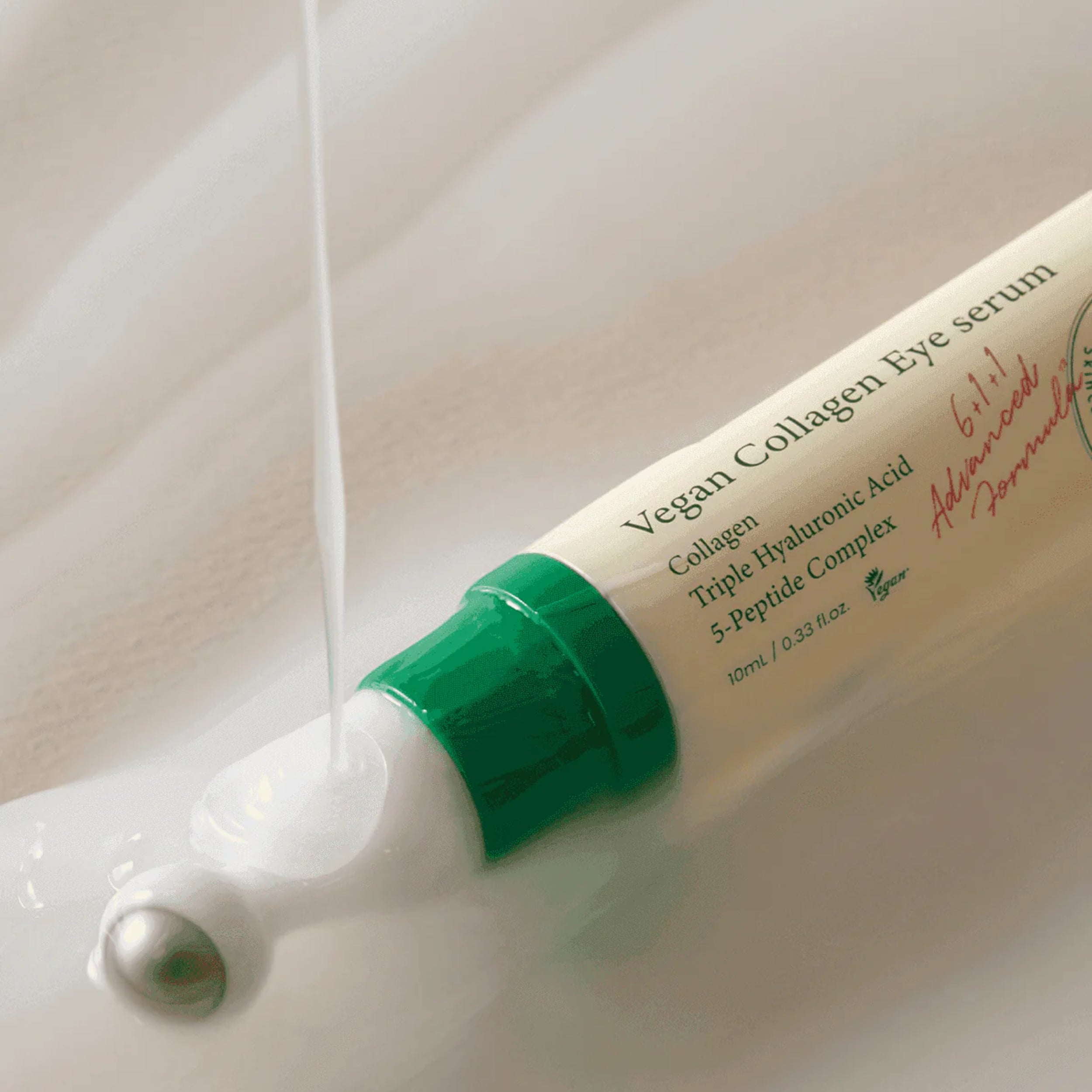 Vegan collagen eye serum being dispensed from a tube on a neutral background