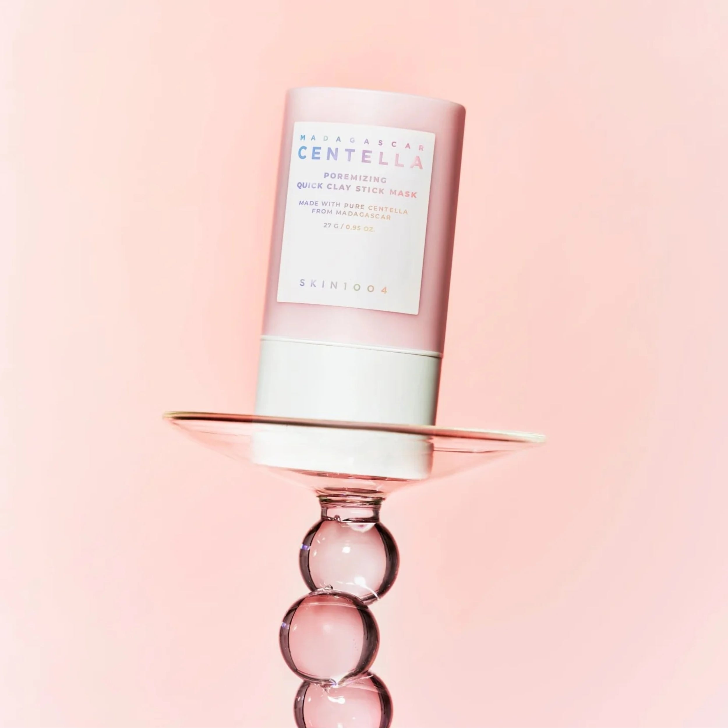 Skincare product on a decorative stand with a pink background