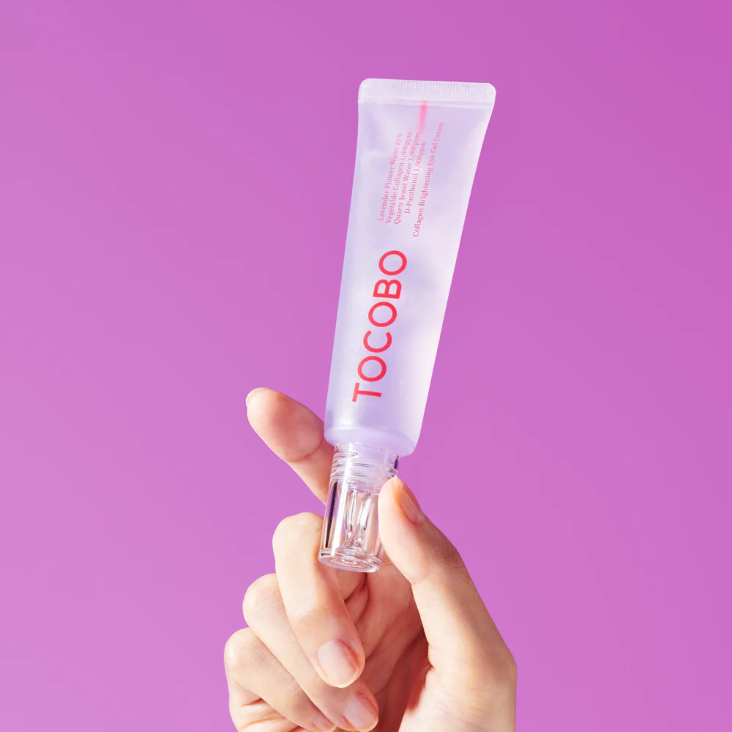 Hand holding a Tocobo skincare product against a purple background