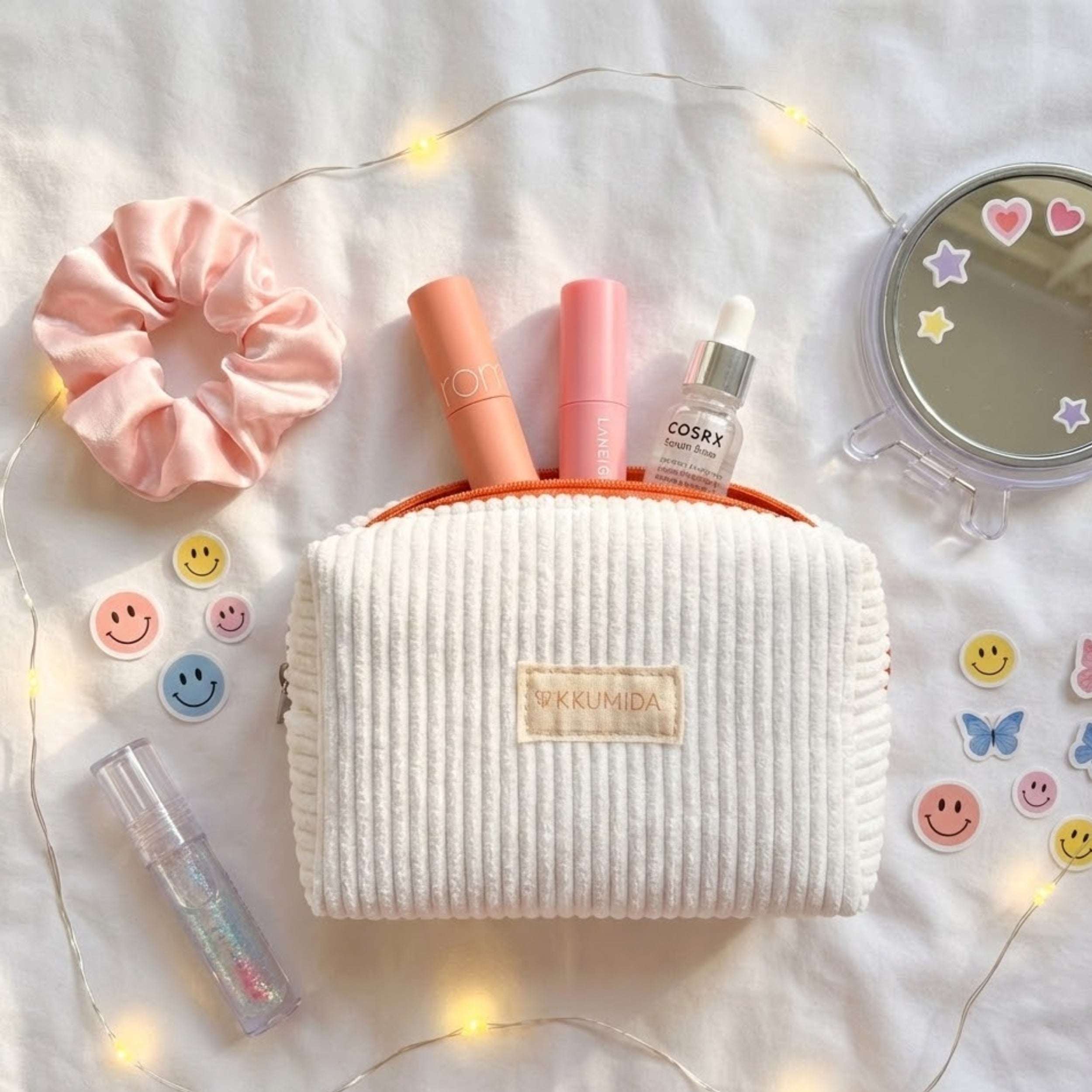White textured makeup bag with cosmetic items on a light background